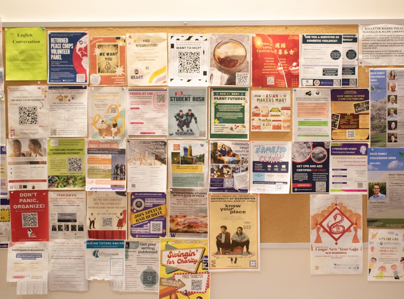 A hand pinning a resource flyer to a community bulletin board layered with other notices.